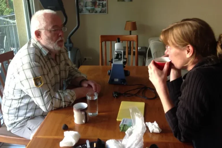 Beratungsgespräch mit Kunde und Sabine Hörnicke sitzen am Tisch bei einer Tasse Kaffee